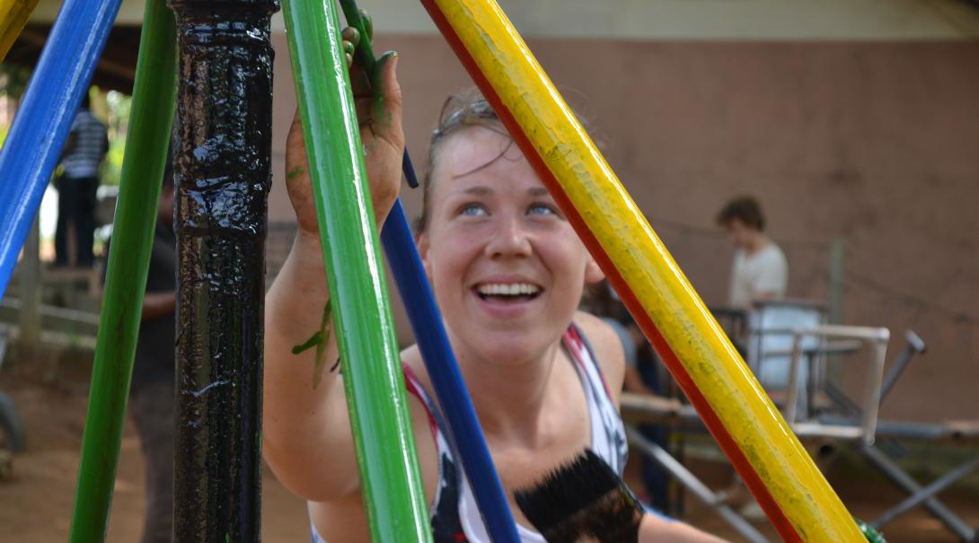 A Projects Abroad volunteer building in Ghana, helps paint a playground A volunteer paints a playground as part of her construction volunteering in Ghana